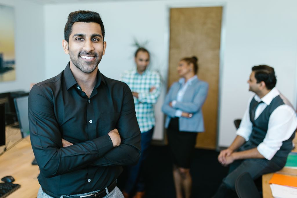 A business man with a group of other business people behind him.
